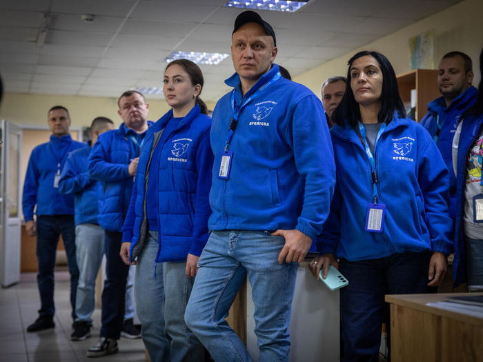 A group of people wearing the same blue vest