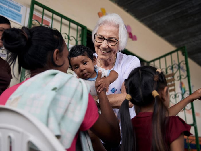 Sister Rosita Milesi holds a baby in her arms