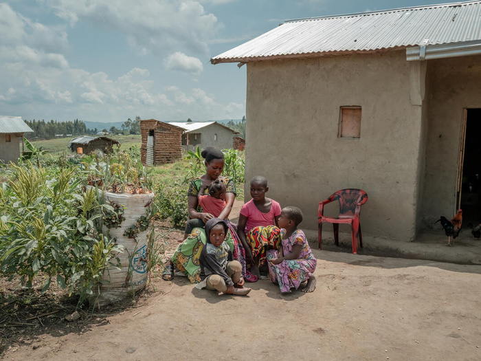 A 24-year-old woman sits outside her home with her four children in a camp for displaced people.