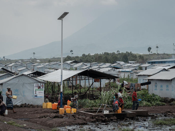 Displaced people collect water at a distribution point built with UNHCR support at the Bushagara site for internally displaced people, near Goma in North Kivu province, Democratic Republic of the Congo.