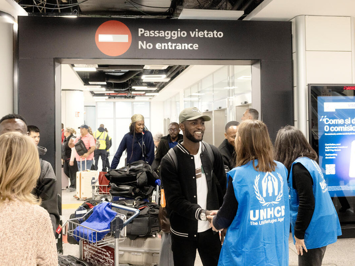 UNHCR staff greet refugees in an Italian airport