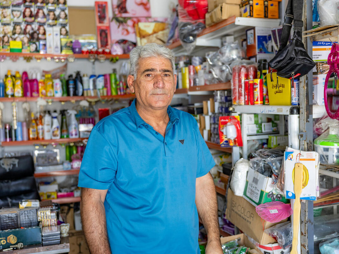 A Syrian man pictured in the crowded shop he runs.