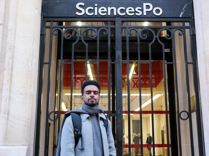 An Eritrean man stands in front of the gates of SciencesPo.