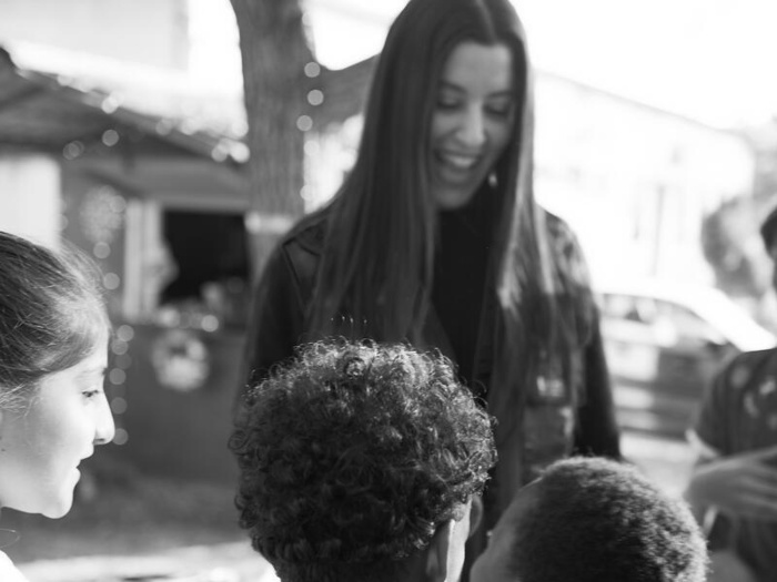 Marina Satti smiles as children gather around her