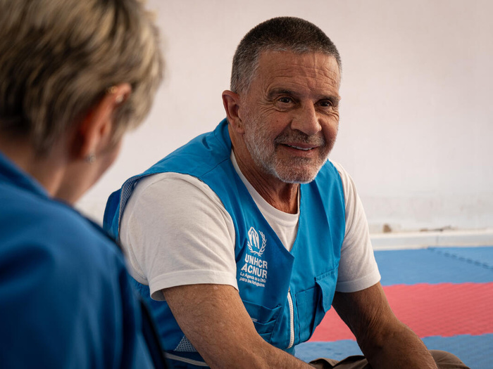 Osvaldo Laport sits smiling in a UNHCR vest.