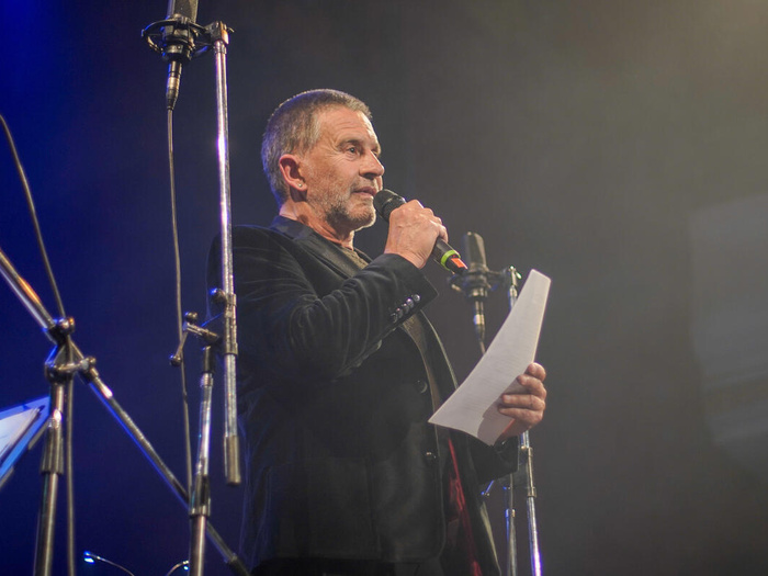 Osvaldo Laport speaks into a micorphone wearing a black jacket