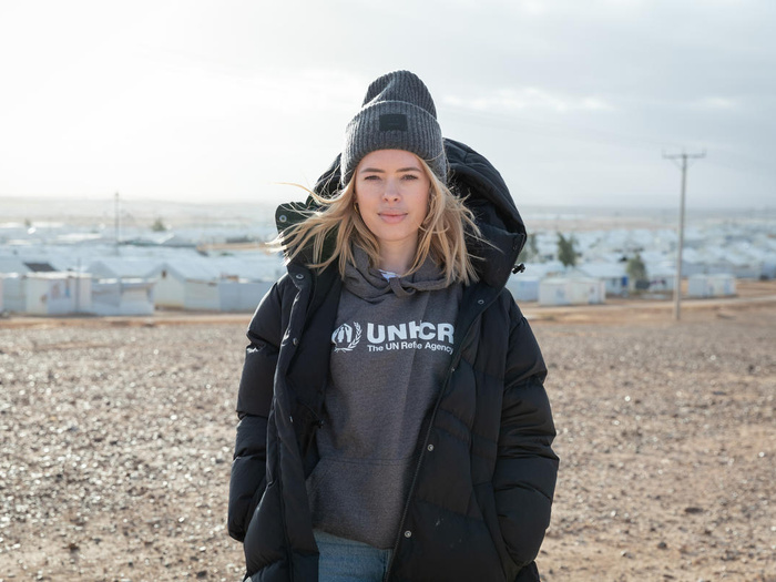 Tanya Burr standing on a high point overlooking a refugee camp.