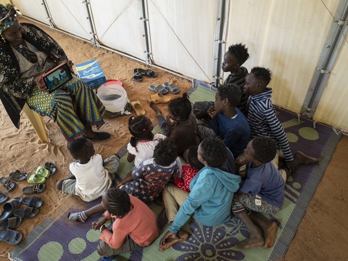 أطفال لاجئون يشاهدون مقطع فيديو لمساعدتهم على تعلم اللغة الفرنسية في مركز الإيواء المؤقت في حمدلايي، بالقرب من العاصمة النيجيرية نيامي. ستكون المهارات اللغوية مفيدة في إيجاد حلول دائمة لهم.