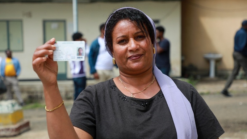 A woman holds her ID card.