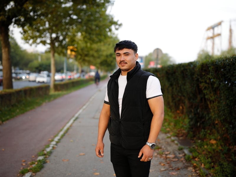 A woman holds up an ID card and license document for the camera. 