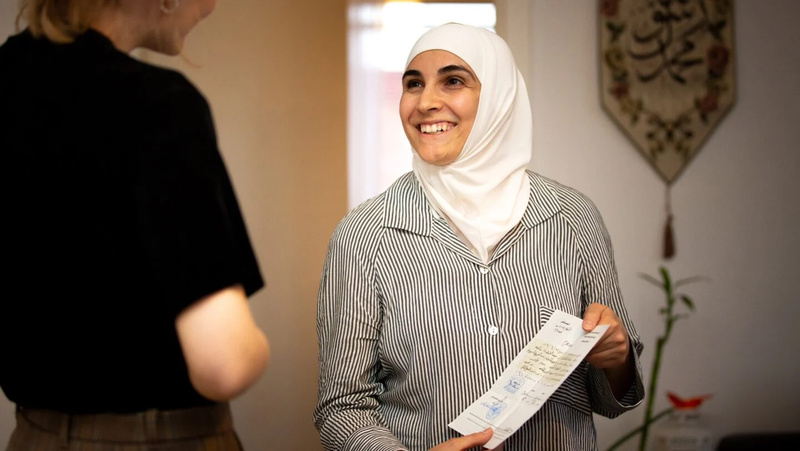 حنان تُظهر شهادتها الجامعية في الطب الحيوي.