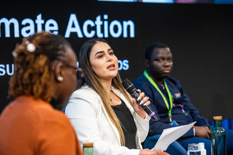 Rez Gardi (au centre), avocate internationale, militante des droits humains et co-directrice de Refugees Seeking Equal Access at the Table (R-SEAT), s'exprimant lors du GRF. 