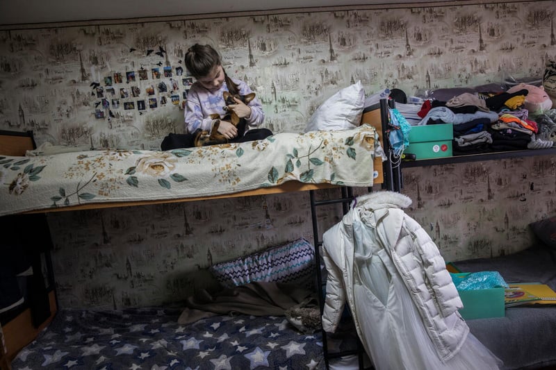 Victoria, 7 ans, et son chien Skya dans un site collectif à Kharkiv en mars 2023.