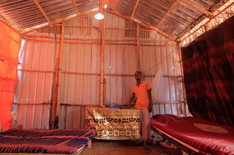 Un homme allume une lumière à l'intérieur de sa maison