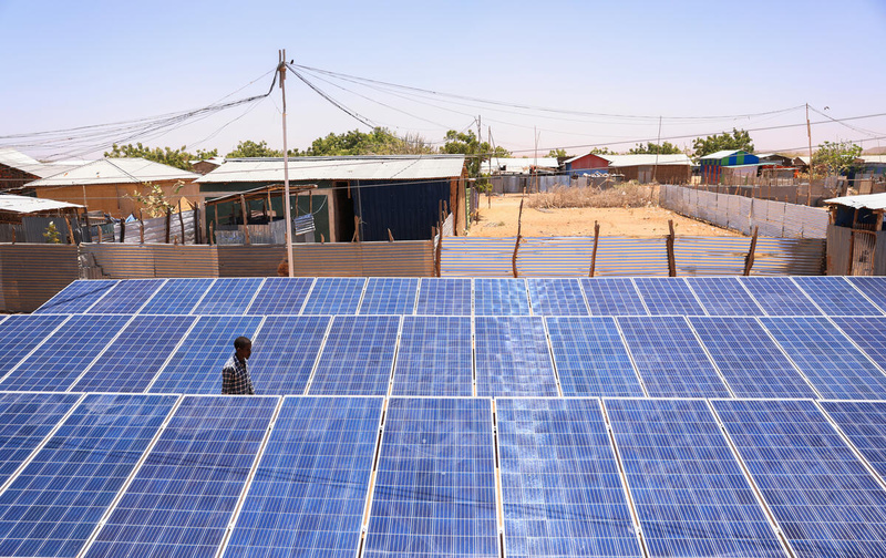 Un homme se promène parmi un mini-réseau électrique solaire