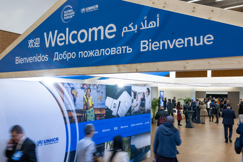 Un panneau de bienvenue, avec le mot "Bienvenue" en plusieurs langues, au-dessus de l'entrée du Forum mondial sur les réfugiés 2023.