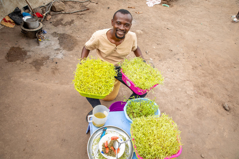 Aerial view of a young man holding trays of fresh produce.