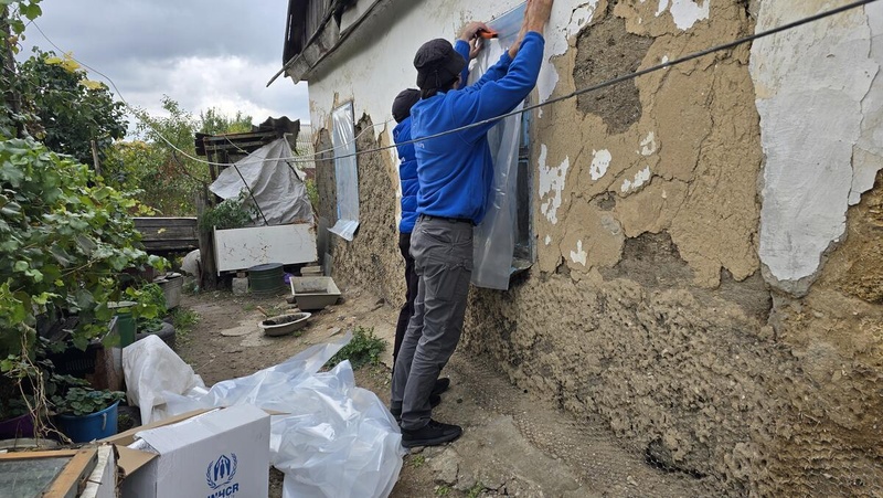 Des travailleurs de Proliska, ONG partenaire du HCR, effectuent des réparations d'urgence sur une maison endommagée à Zaporijia, une autre zone de front en Ukraine