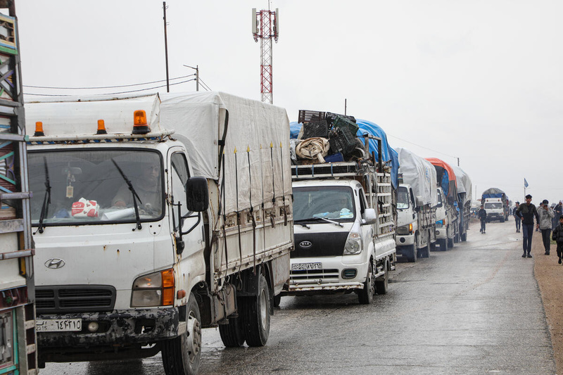 Une rue remplie de camions chargés d'effets personnels.