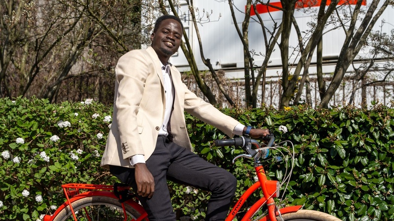 Stephen poses for the photo, sitting on his red bike