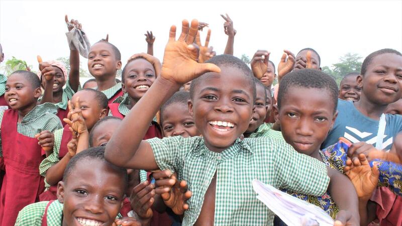 A group of Cameroonian refugees and local children enjoy taking a photograph together during a break from class.
