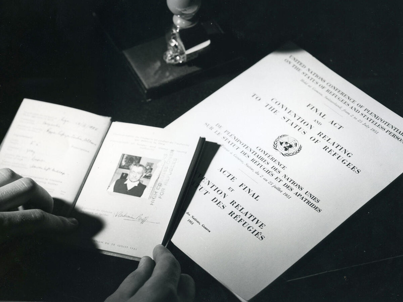 A black and white photo showing travel documents and The Convention Relating to the Status of Refugees.