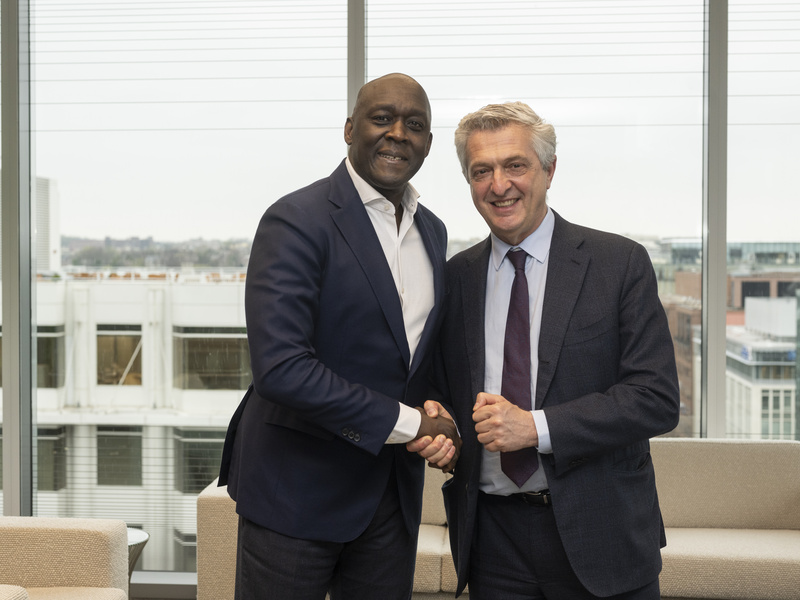 Two men shaking hands and posing for the camera