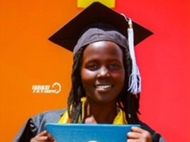 Nyanen wears a graduation gown and smiles for the camera