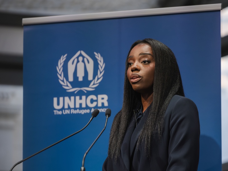 Jeny Bosenge speaking into a microphone on a stage