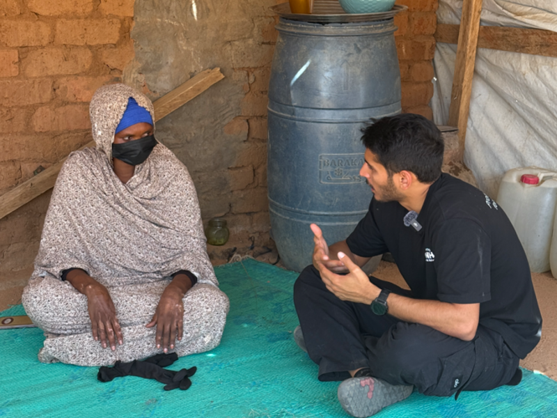 Omar sits and speaks with a Sudanese woman