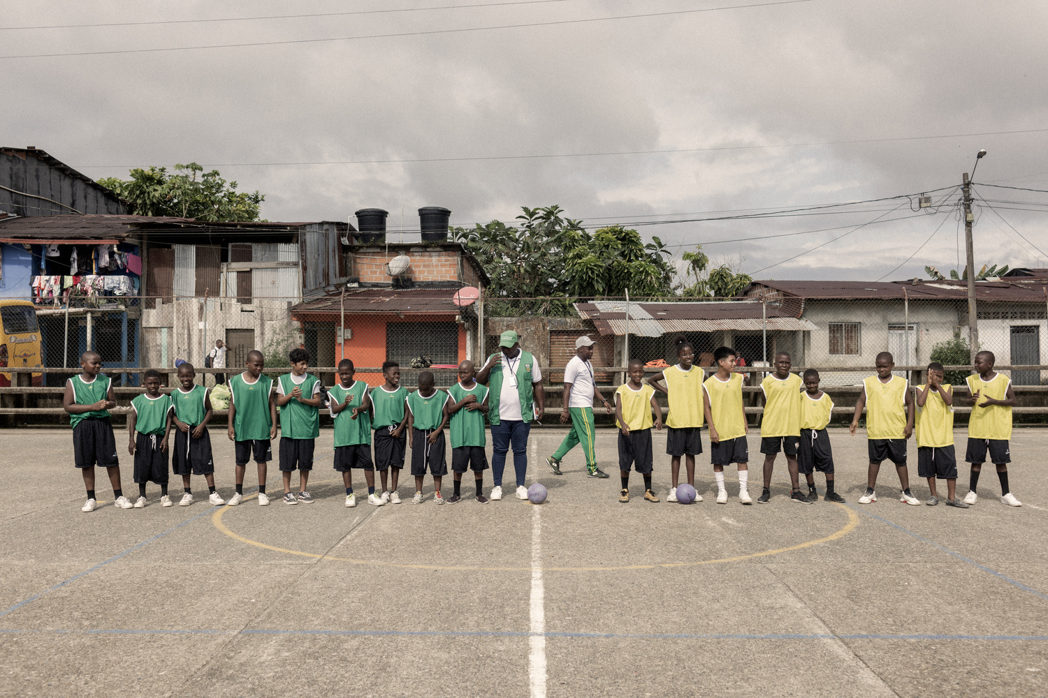 Des enfants portant des dossards verts d'un côté et jaunes de l'autre se préparent à jouer au football