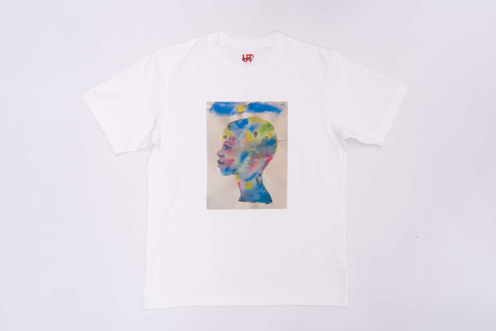 A white t-shirt with an illustration of a face covered in various colors.