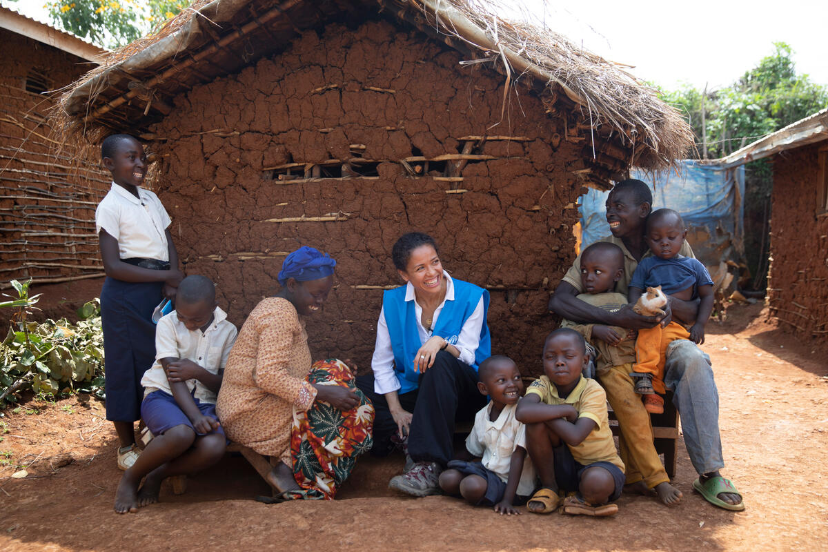Gugu Mbatha-Raw sits with a family of refugees in the shadow of their house.