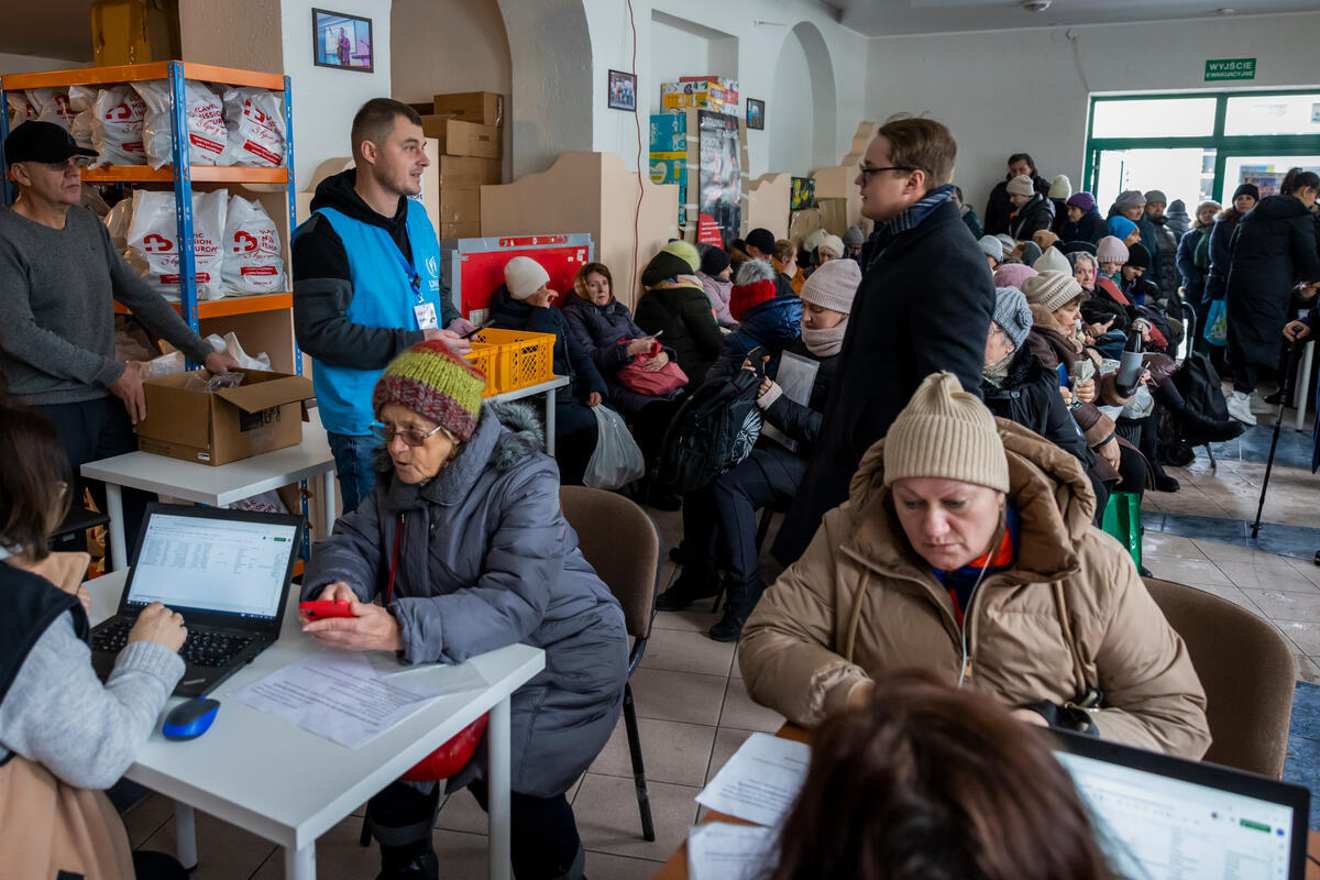 Ukrainian refugees sit inside an aid distribution centre in Poland.