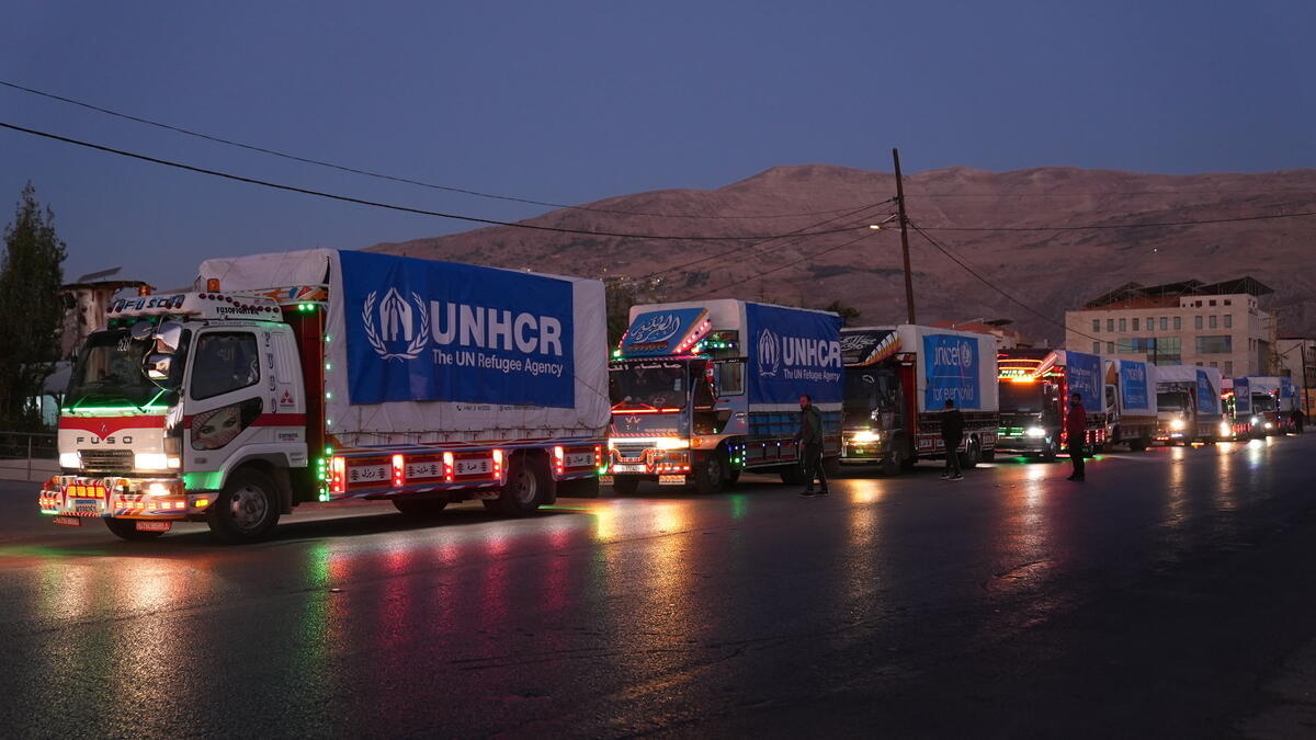 A convoy of UNHCR humanitarian aid trucks at sunrise