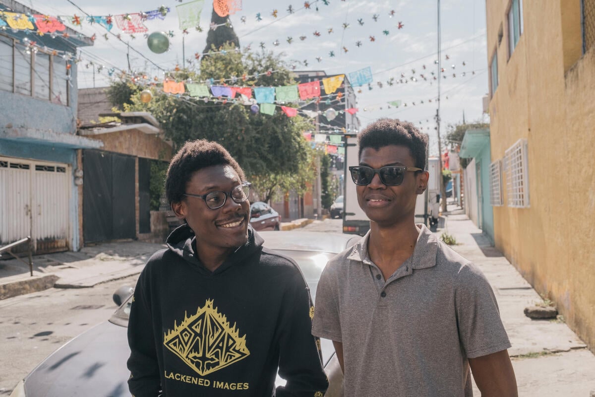 Two men walk down a street together in Mexico City.