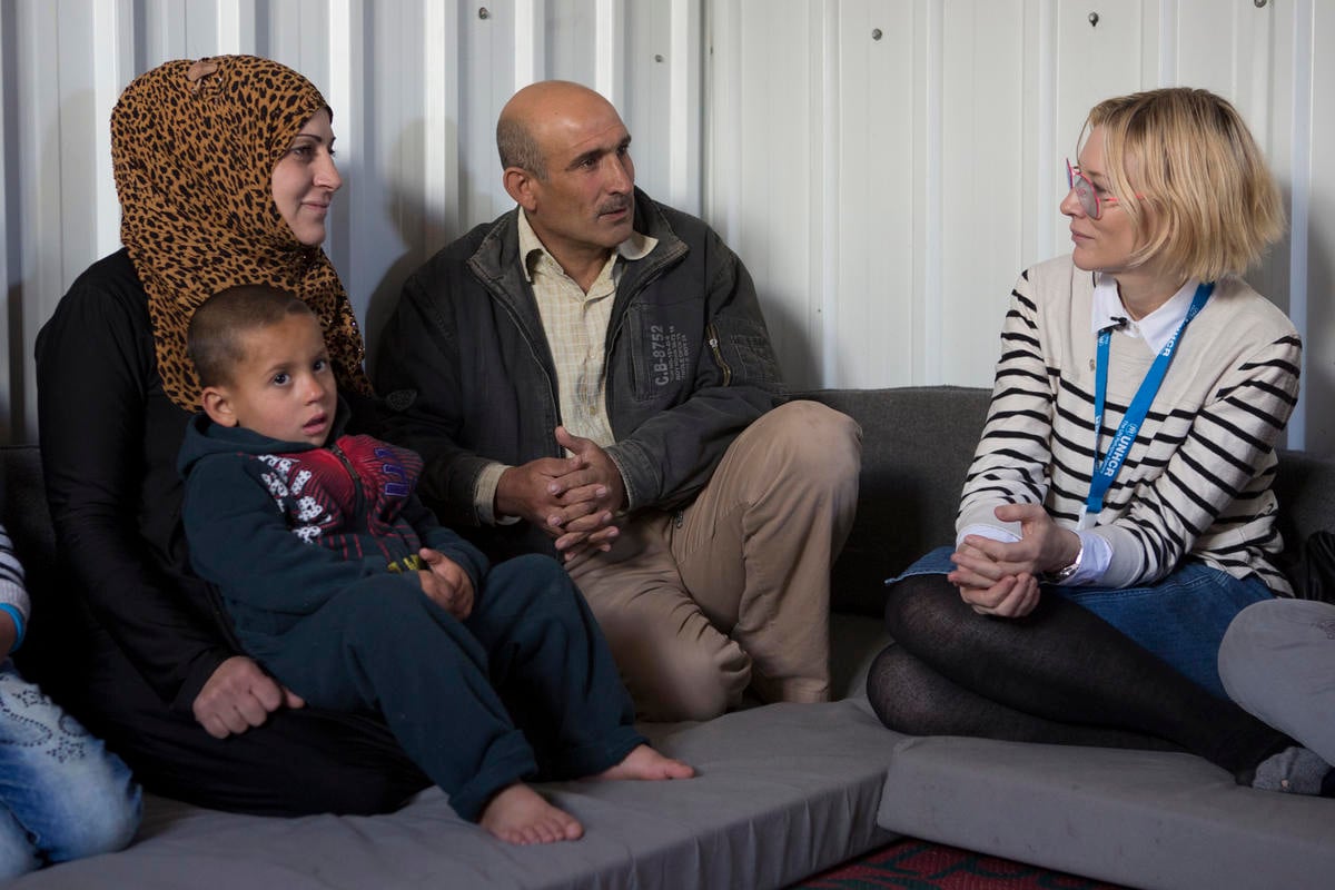Cate sitting on a couch with a mother, father and their child