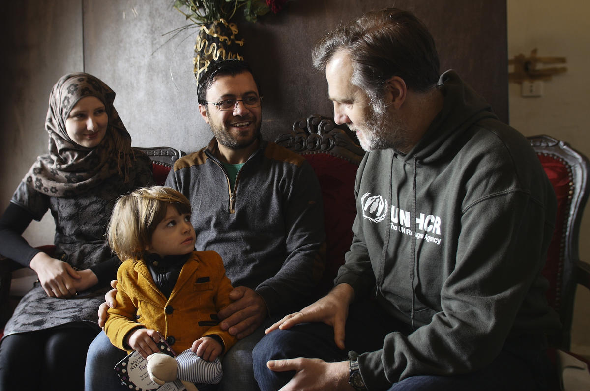 David Morrissey sits next to a family of Syrian refugees.