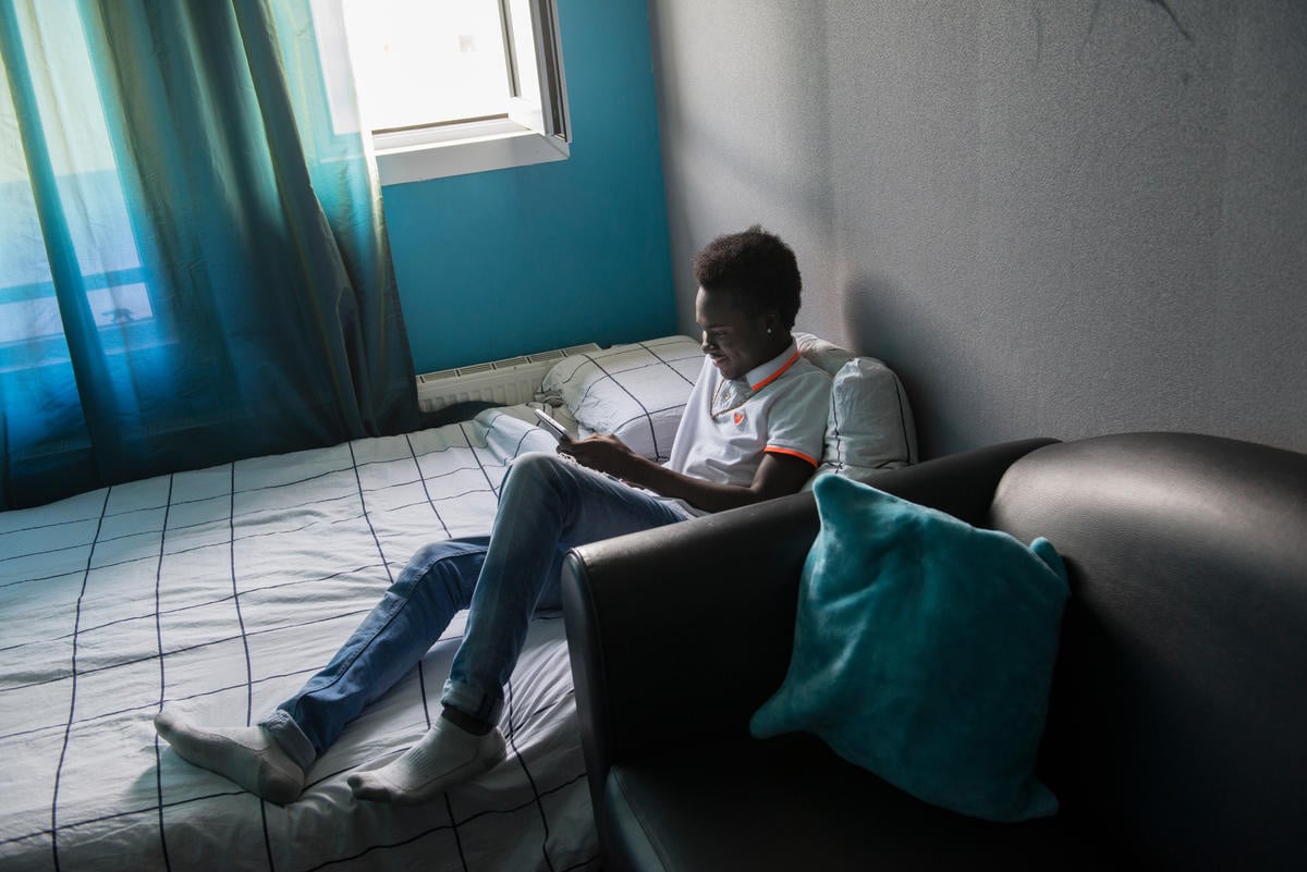 Samuel* sits on his bed reading