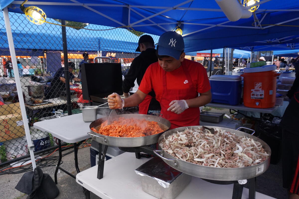 USA – A staffer at a stand at the Queens Night Market in New York City.
