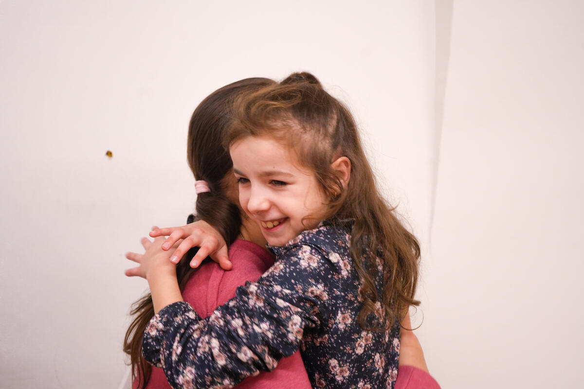 María abraza a su madre Liudmyla, quien afirma que las sesiones con Noir han tenido un impacto positivo en su hija.