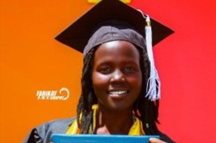 Nyanen wears a graduation gown and smiles for the camera