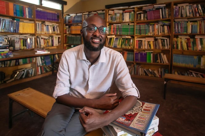 Abdullahi Mire sits smiling in a library