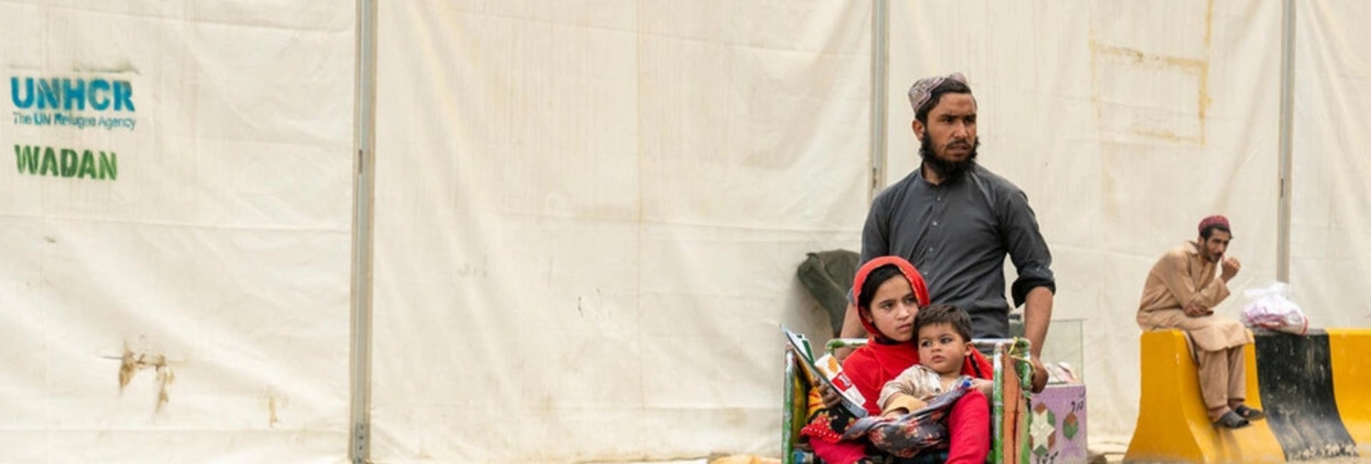 Hadigul porte ses jeunes sœurs, Sabria et Freshta, alors qu’ils voyagent ensemble après leur récent retour en Afghanistan. Malgré les épreuves qu’ils ont traversées, cette famille très unie fait preuve de résilience et de force pour aller de l’avant.