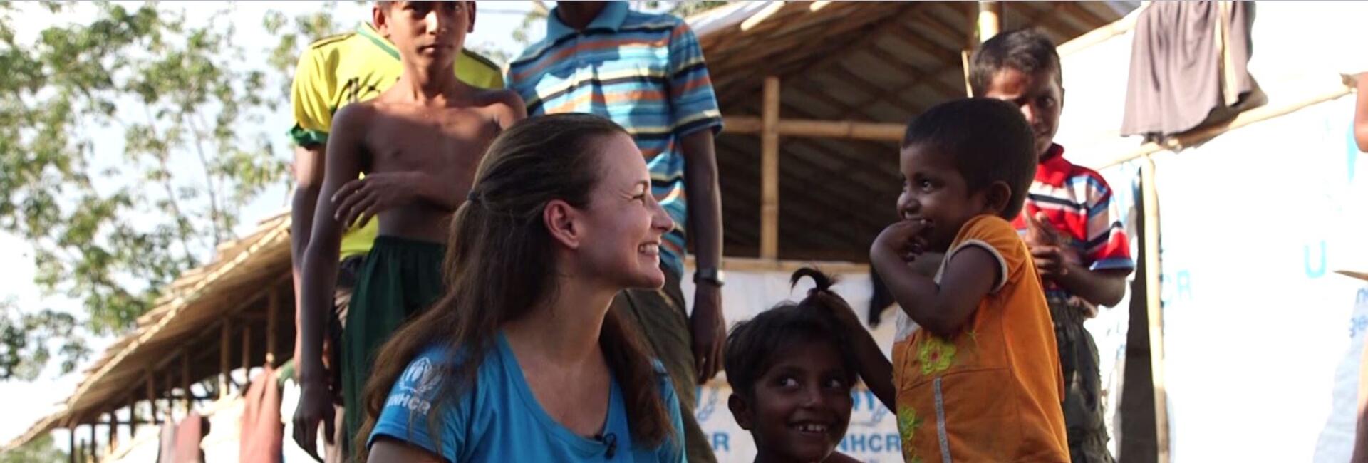 Kristin Davis smiling with several Rohingya refugee children