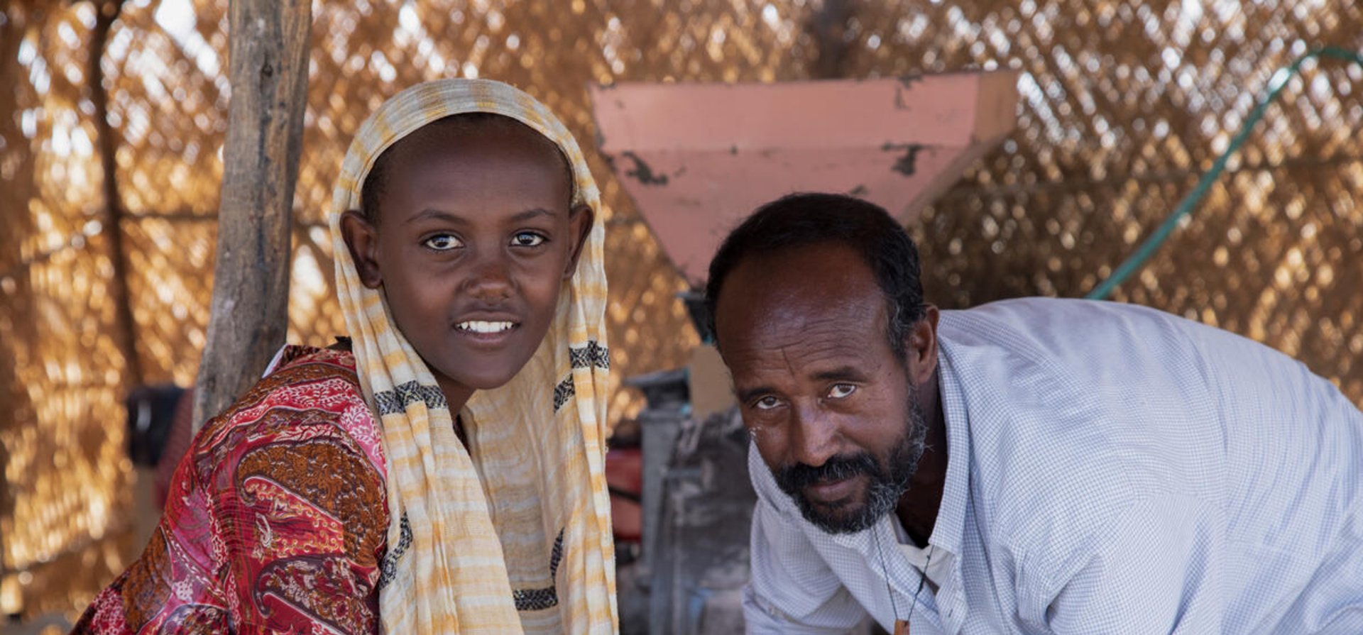 Ethiopian man stands next to a young Ethiopian girl.