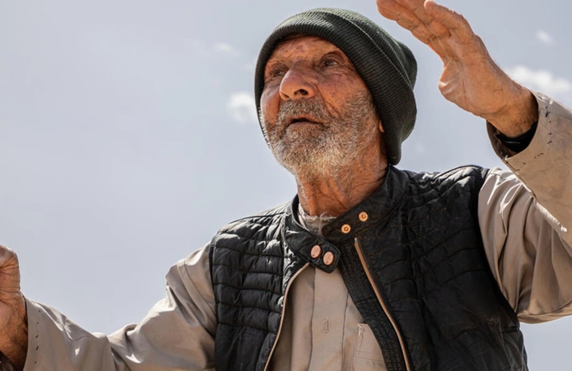 جاسم، أحد العائدين السوريين، يقف بالقرب من أنقاض منزله السابق في ريف القصير، محافظة حمص.