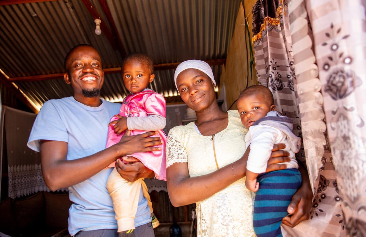 A smiling mother and father hold their two children.