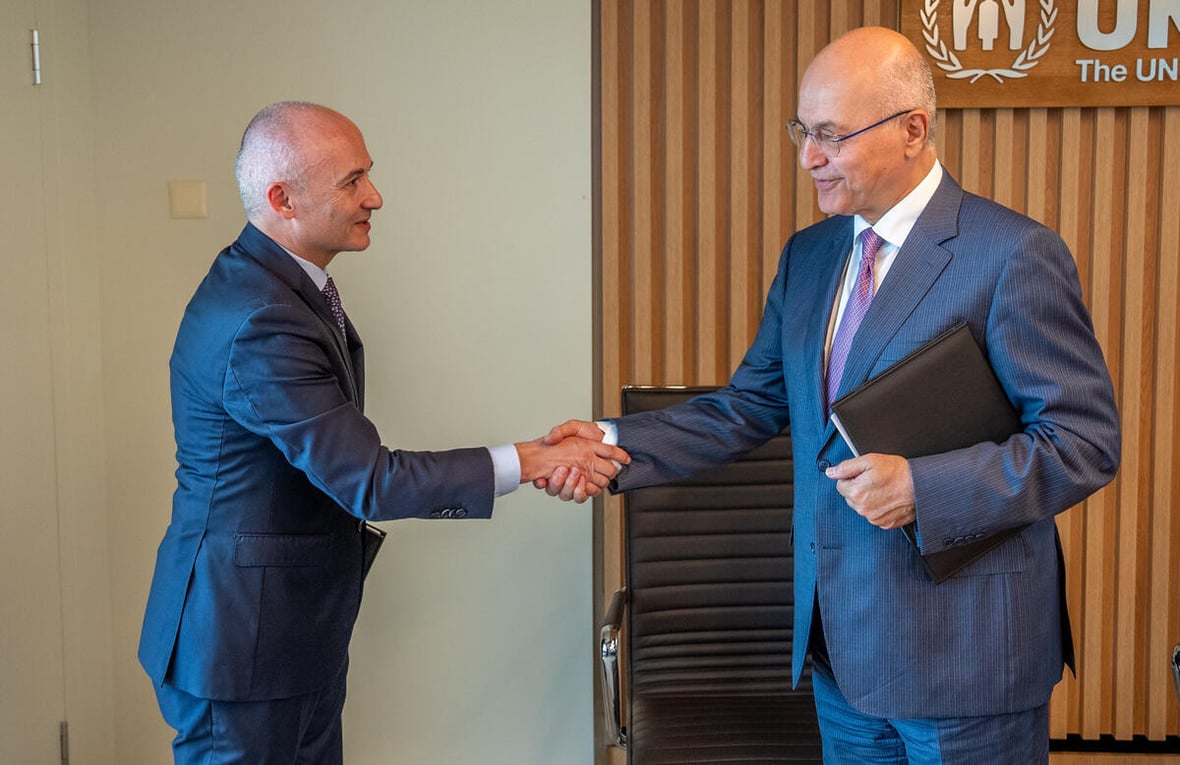 Barham Salih and Óscar García Maceiras shake hands, smiling