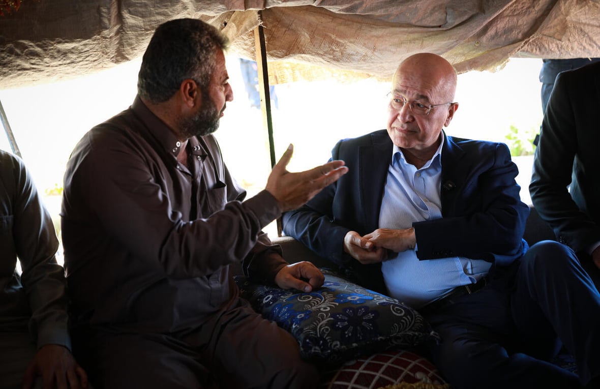UN High Commissioner for Refugees Barham Salih talks with a displaced man in a shelter in Al-Hijra Camp.